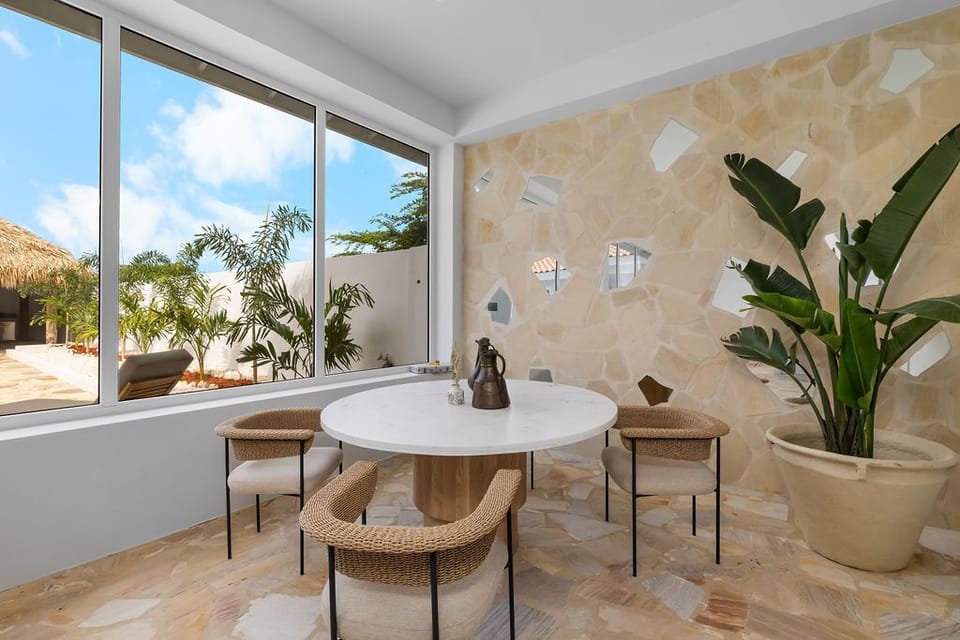 The open-plan layout, large windows, and neutral color palette create a peaceful and inviting atmosphere.