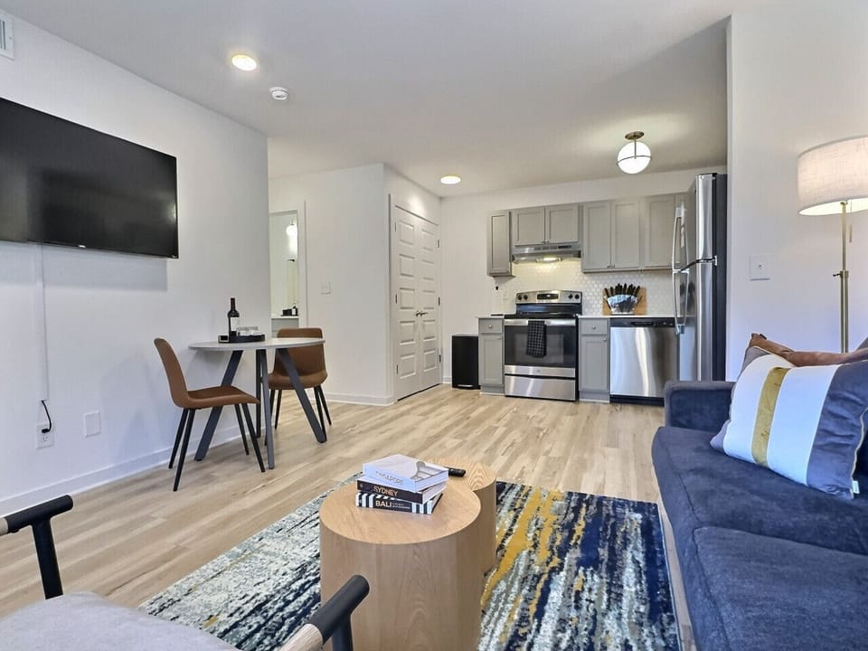 Relax in a stylish living area featuring a Smart TV and comfortable seating, perfect for unwinding during your short-term rental stay.