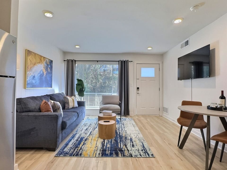 Relax in a stylish living area featuring a Smart TV and comfortable seating, perfect for unwinding during your short-term rental stay.