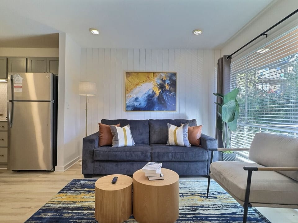 An elegant living area in Downtown Birmingham that blends modern design, natural light, and cozy touches for the perfect stay.