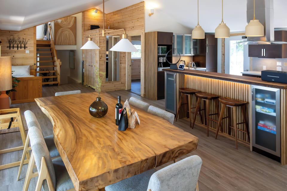 Gather around the dining table and enjoy a delicious meal in this cozy and inviting space. The warm glow of the fireplace and the soft ambient lighting create the perfect atmosphere for relaxation and conversation. The open-concept design allows for seamless flow between the dining area, living room, and kitchen.