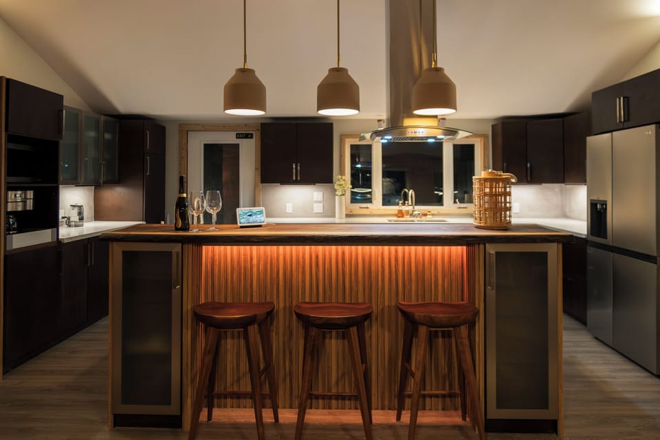 Gather around the kitchen island and enjoy the warm glow of the pendant lights. This inviting space is perfect for enjoying a glass of wine and catching up with loved ones.