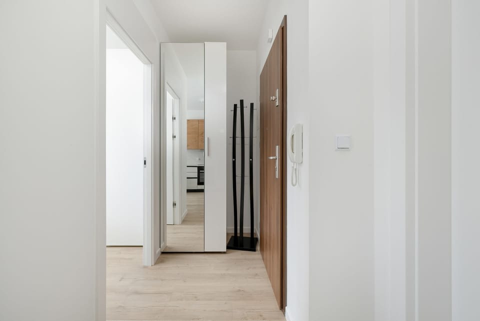 A compact corridor leading to the bedroom and kitchen. Clean white walls enhance the sense of space.