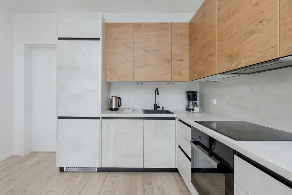 A well-organized kitchen area featuring a dishwasher and induction cooktop. Wooden finishes add a cozy touch.