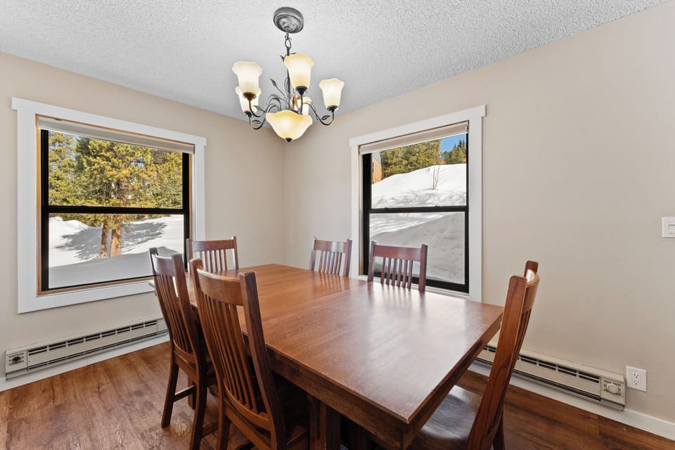 Gather around your elegant dining table where warm chandeliers illuminate memorable meals together.