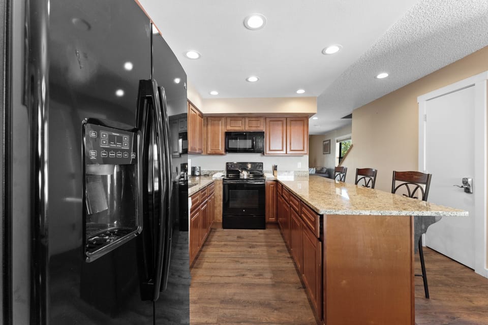Your fully equipped kitchen features granite countertops, modern appliances, and a breakfast bar where you can enjoy morning coffee.
