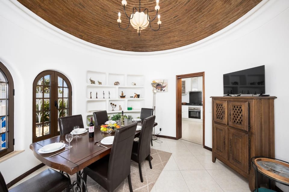 Open-plan living room with sofas, dining area, ornamental fireplace, A/C, WiFi internet, and satellite TV