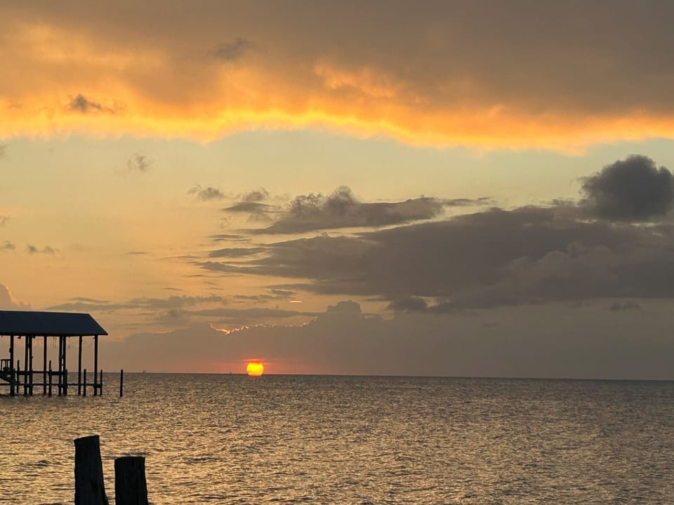 A stunning sunset view over the shimmering water creates a serene atmosphere, perfect for relaxation and reflection
