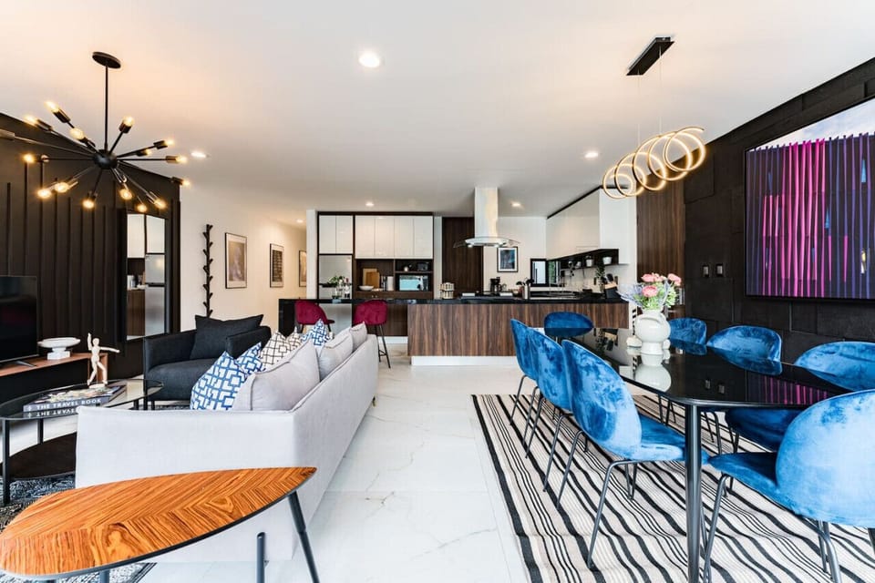 Open-concept living space featuring chic furniture and vibrant blue accents.