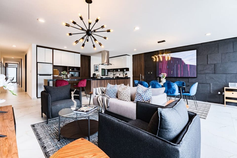 Spacious living room with unique light fixtures and cozy seating, perfect for entertaining.