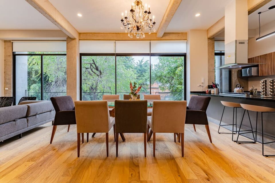 Bright dining space with seating for six and lush green views.