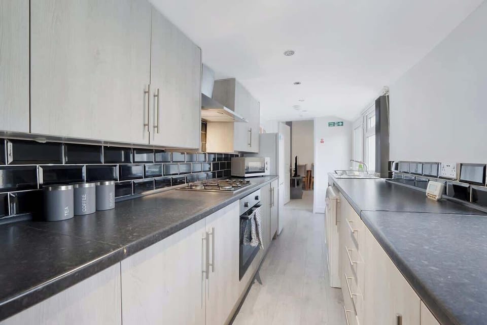 Kitchen equipped with all essentials, including a microwave, oven, toaster, kettle, fridge and full cookware set.