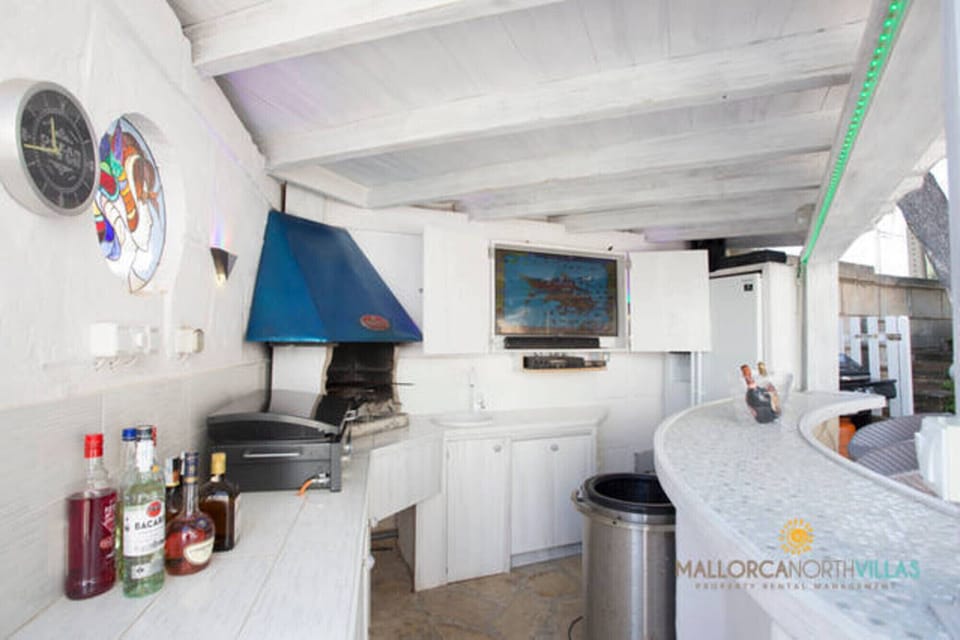 Outdoor bar with barbecue and preparation area on covered terrace at Villa Ocean View, Portals Nous.