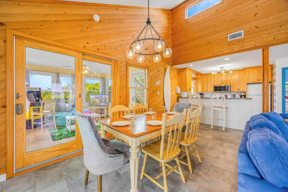 Gather around this inviting dining table where warm wood tones and coastal charm create the perfect space for your morning coffee or evening meals together.
