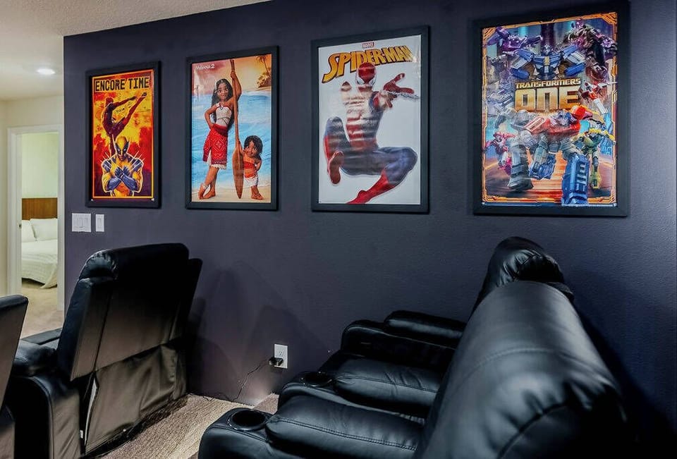 Step into a cozy entertainment area featuring plush black reclining seats, perfect for movie nights. The bold superhero posters add a fun touch, creating a lively atmosphere that invites relaxation and enjoyment.