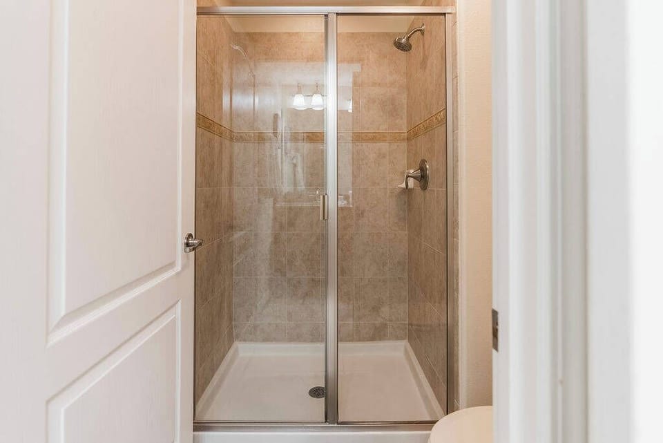 Step into the spacious shower featuring sleek glass doors and stylish tile accents that create a clean, refreshing ambiance. Enjoy the practicality of the well-designed layout, perfect for unwinding after a day of adventure.