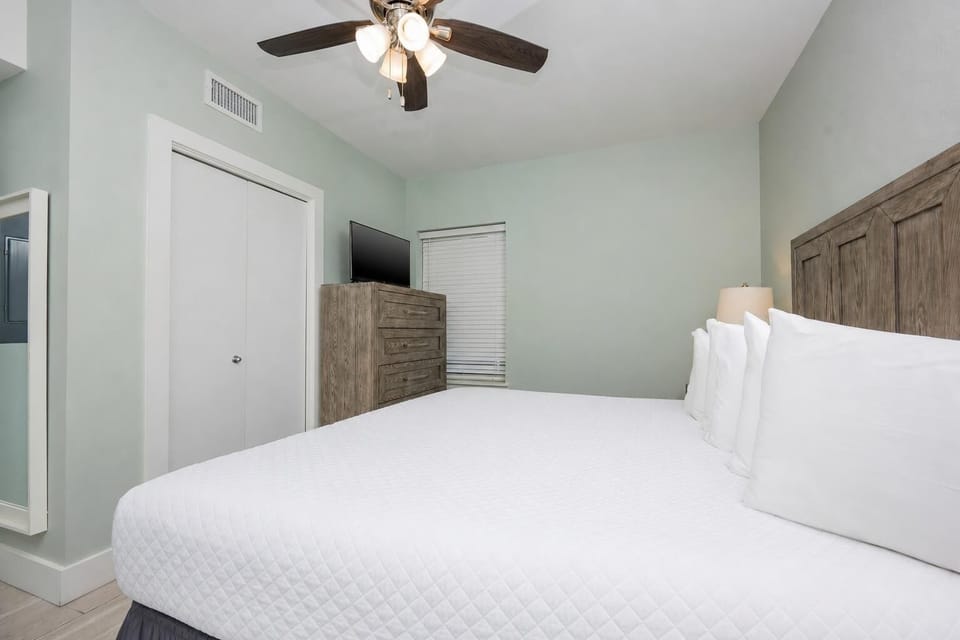 Relax in this serene bedroom featuring a king bed, soft linens, and a stylish dresser for your belongings