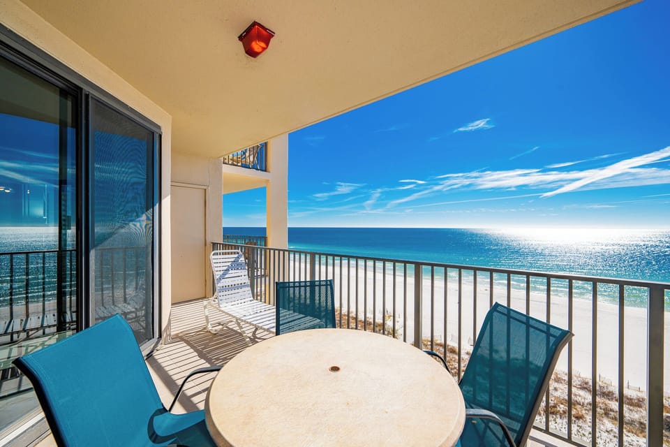 Relax at the round table with chairs, enjoying the expansive views of the shimmering water and bright blue sky