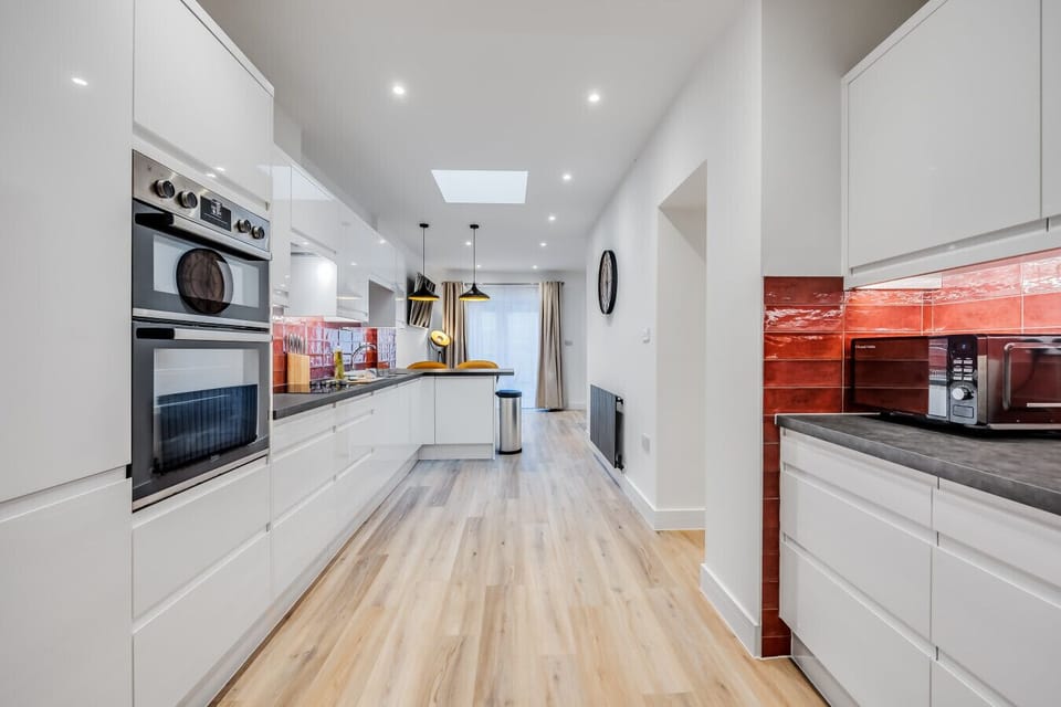 A fully equipped kitchen with a fridge freezer, oven, stove, microwave, dishwasher, kettle, toaster, cookware, tableware, and utensils all provided