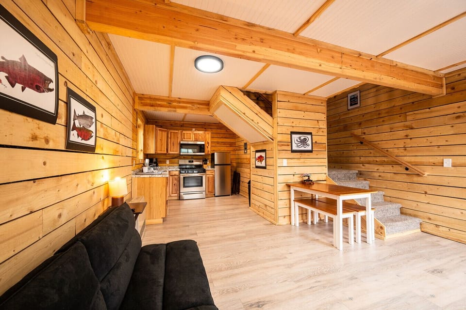 Open living, kitchen, and dining layout offering comfort and convenience in a warm Alaskan cabin setting.