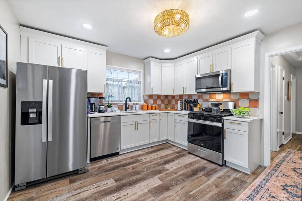 Fresh + Functional – This updated kitchen combines crisp white cabinetry with warm tile accents and ample counter space.