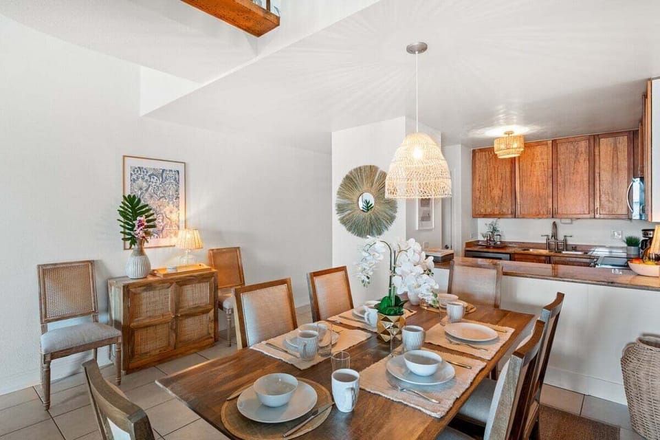 Open dining space with tropical décor, soft lighting, and seamless connection to the kitchen and living area.