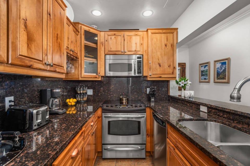 This kitchen has new stainless steel appliances and a breakfast bar to enjoy a cup of coffee in the morning.