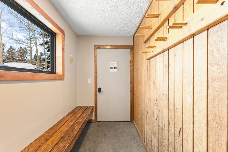 You'll love unwinding in this cozy entry with warm wood accents and peaceful winter views through the large window.