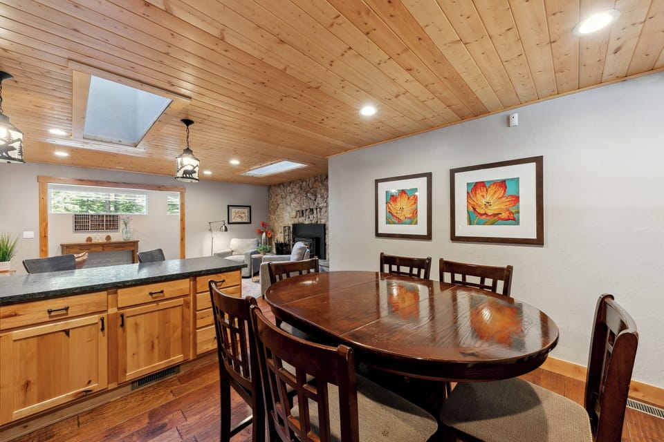 Gather around this inviting dining space where warm wood ceilings and natural light create the perfect setting for memorable meals together.