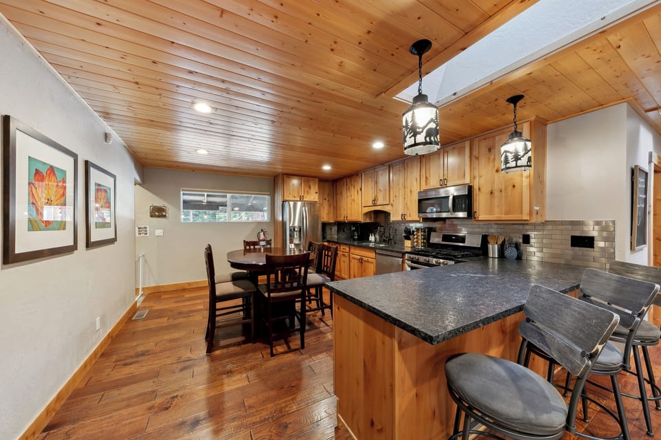 Your fully equipped kitchen invites culinary adventures with rich wood cabinets, granite counters, and cozy dining nook perfect for morning coffee or evening meals.