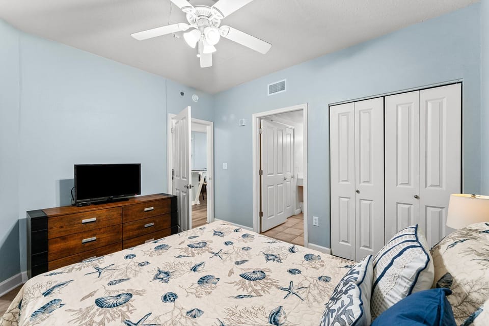 bedroom with coastal-themed bedding and a ceiling fan