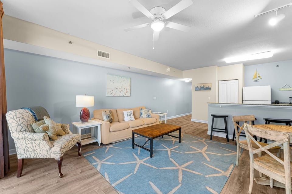 spacious living area with coastal-inspired decor and an open kitchen layout