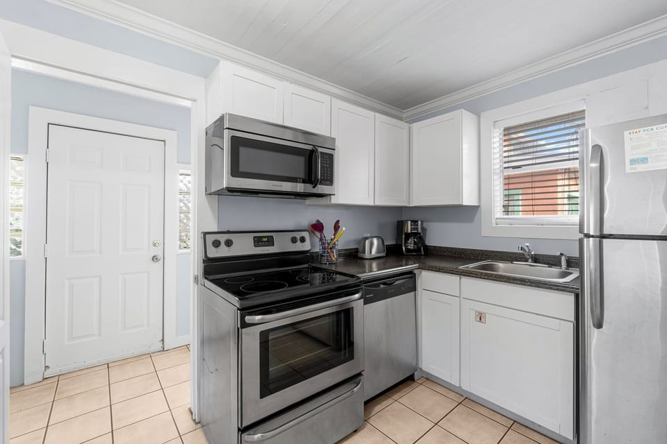 Modern kitchen with stainless steel appliances and natural light from the window.