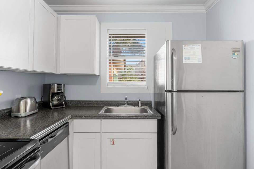 Compact kitchen with stainless steel appliances and a window for natural light