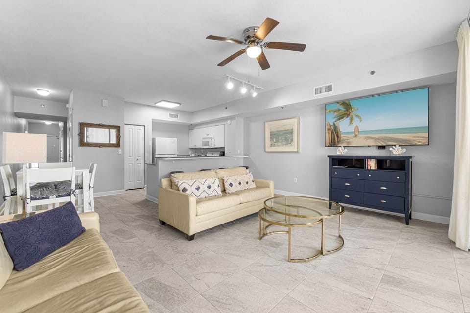 Open-concept living area with modern furnishings and coastal artwork.