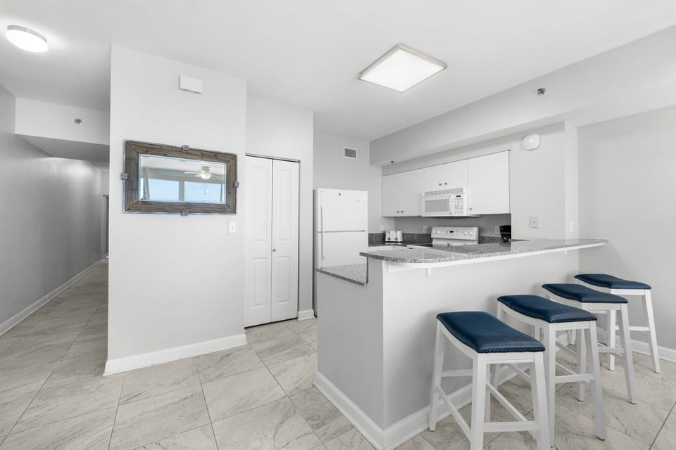 Sleek kitchen w/ bar seating — a great spot for quick bites or morning coffee.