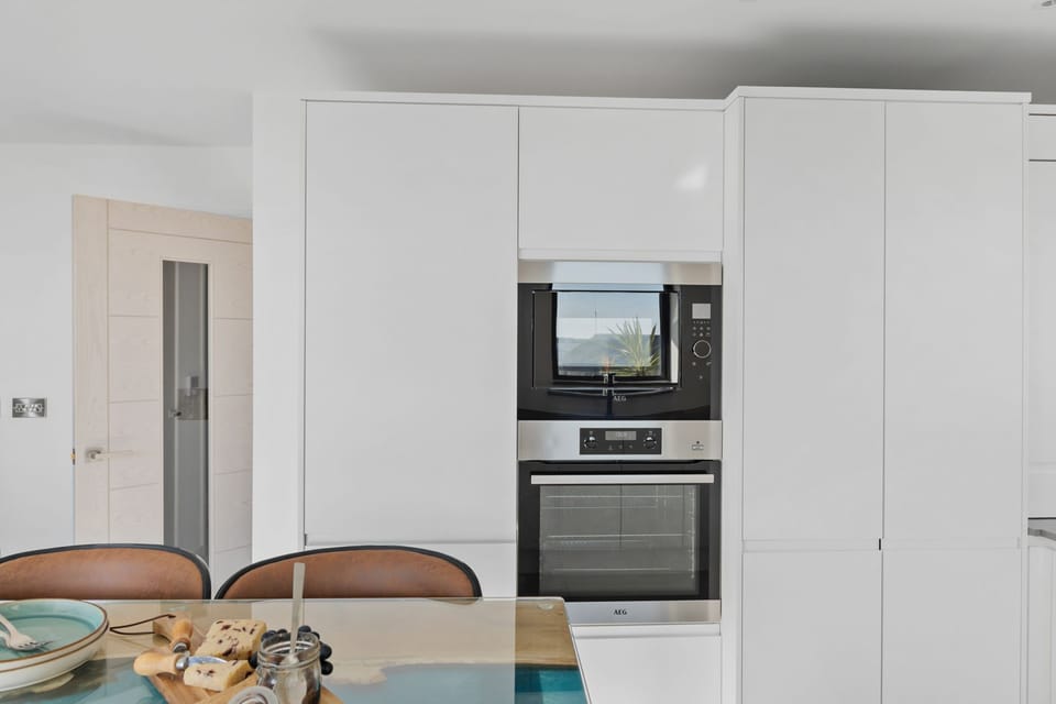 An oven, microwave and dining room - Estuary View