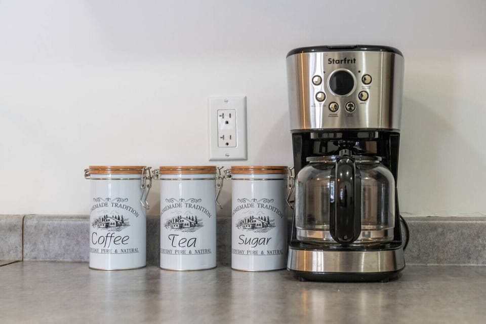 Full kitchen with a drip coffee machine, kettle, fridge, stove, microwave, toaster & kettle.