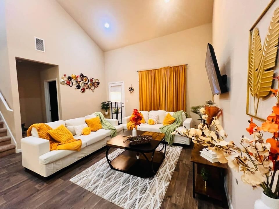 Spacious living room with bright decor, cozy seating, and a Smart TV, perfect for relaxing evenings. Conveniently located near Lake Kyle and local shopping.

