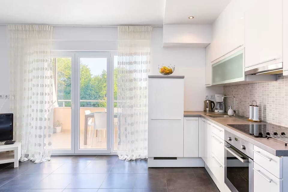 Kitchen with oven, stove, fridge, and dining table