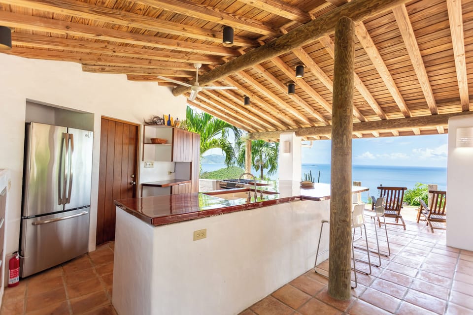 Open air kitchen with full size fridge/ freezer & pantry door. 