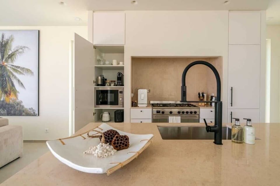 A chef’s dream kitchen with a SMEG gas stove, pot filler, and a fully stocked coffee station featuring SMEG and NESPRESSO machines, plus a milk frother for cappuccinos. Cook with Zwilling knives, top-quality cookware, and a curated spice selection