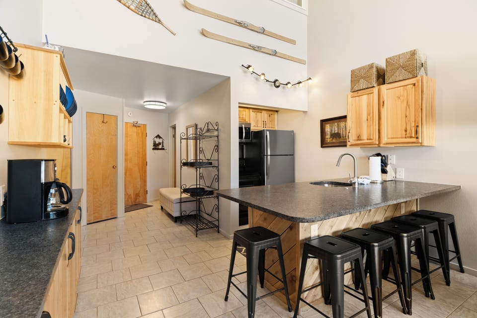Your mountain-inspired kitchen blends rustic charm with modern convenience, featuring warm wood cabinets and a granite island perfect for gathering.