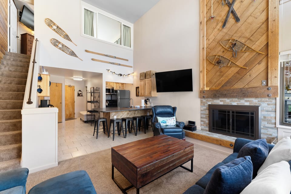 Living room with sleeper sofa, gas fireplace, smart TV, and workspace.