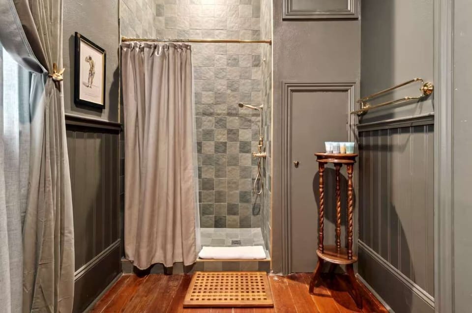 First-floor bath with an oversized walk-in shower, brass fixtures, and slate-tile surround—spa-style and convenient.