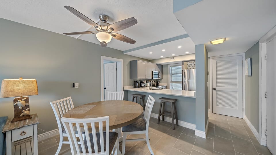 The fully renovated kitchen features new stainless steel appliances, sleek gray cabinetry, and a convenient breakfast bar, making it a joy to prepare meals during your Longboat Key getaway.