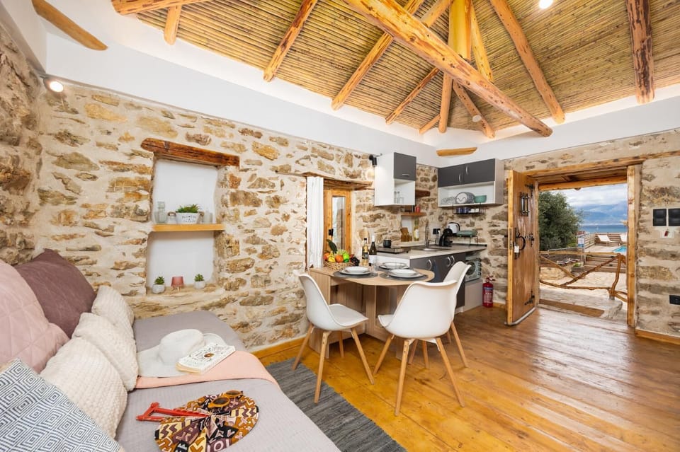 Open-plan living room with sofa-bed, dining area, kitchen, A/C, WiFi internet, and satellite TV