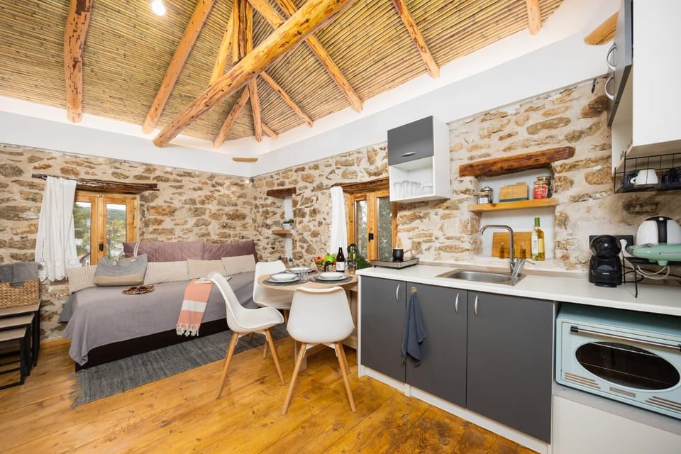 Open-plan living room with sofa-bed, dining area, kitchen, A/C, WiFi internet, and satellite TV