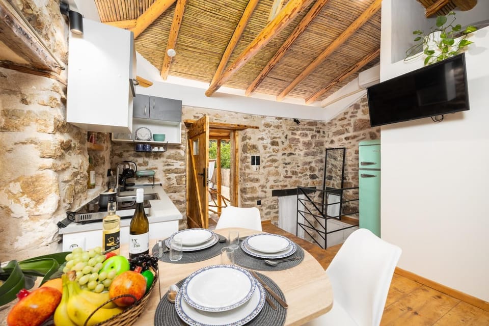 Open-plan living room with sofa-bed, dining area, kitchen, A/C, WiFi internet, and satellite TV
