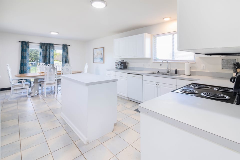 This modern kitchen features top-of-the-line appliances and ample counter space, making it a chef's dream. The tasteful design and lighting create an inviting and functional space perfect for culinary exploration.